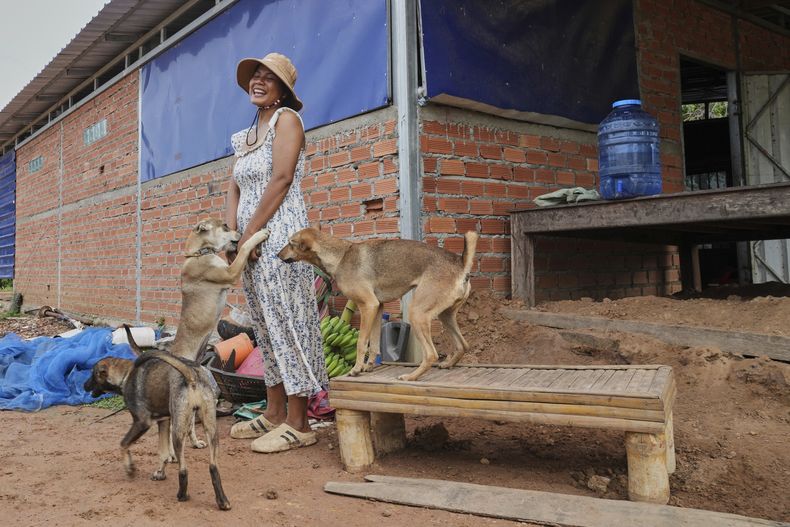 Una mujer camboyana, Soklang Sareoun, de 28 años, saluda a sus perros al regresar a casa después de cinco días en el pueblo de Prasat Roboeuk, provincia de Oddar Meanchey, Camboya, el martes 29 de julio de 2025 después de que entrara en vigencia un cese el fuego el lunes por la noche entre Tailandia y Camboya. (AP Foto/Heng Sinith)