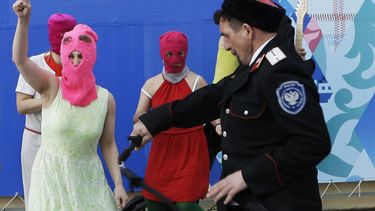 americateve | Un miliciano cosaco, derecha, golpea con un l&aacute;tigo a integrantes del grupo punk Pussy Riot el mi&eacute;rcoles, 19 de febrero de 2014, en Sochi, Rusia. (AP Photo/Morry Gash)