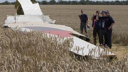 ARCHIVO - Investigadores australianos y holandeses examinan una pieza del avión de Malaysia Airlines derribado cerca de la localidad de Hrabove, en una zona de la provincia oriental ucraniana de Donetsk, controlada por prorrusos, el 1 de agosto de 2014. (AP Foto, archivo)