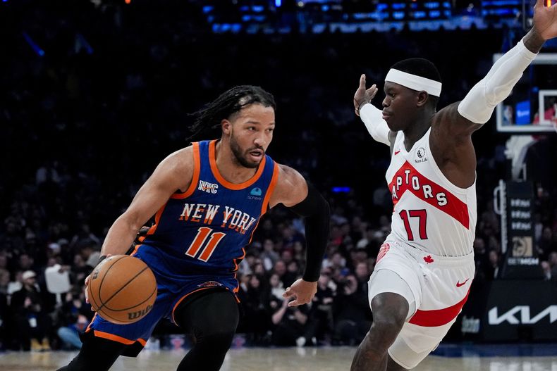 Jalen Brunson, base de los Knicks de Nueva York, avanza a la cesta frente a Dennis Schroder, de los Raptors de Toronto, en el partido del sábado 20 de enero de 2024 (AP Foto/Peter K. Afriyie)