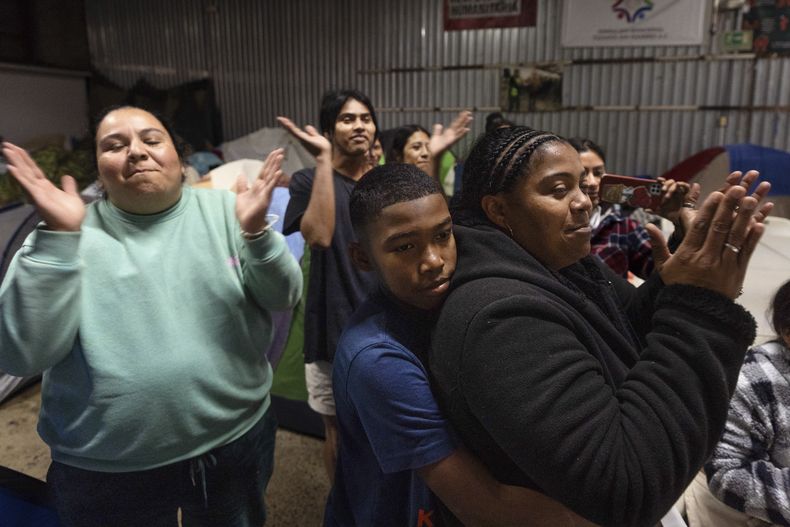 Margelis Rodríguez, a la derecha, de Venezuela, recibe un abrazo de su hijo Mickel durante una fiesta de cumpleaños en un refugio para migrantes en Tijuana, México, el miércoles 5 de febrero de 2025. (AP Foto/Gregory Bull)