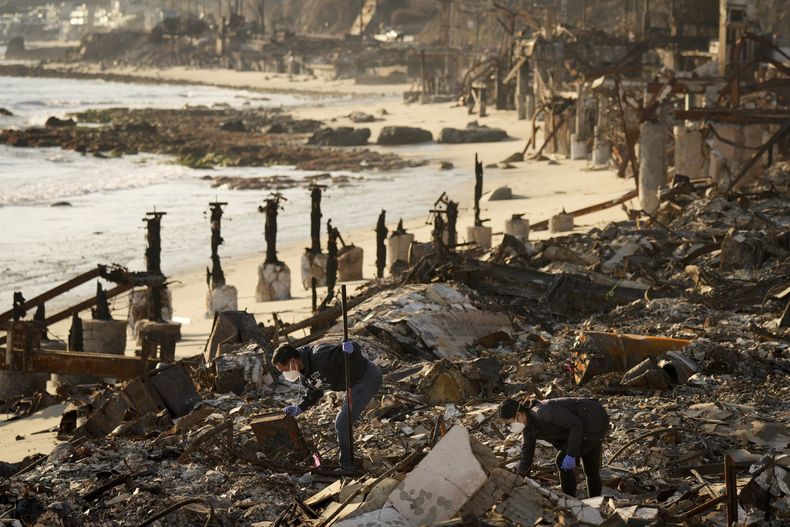 Tony Lai, a la izquierda, mira los restos de su propiedad frente a la playa devastada por el incendio con su esposa Everlyn después del incendio Palisades el martes 28 de enero de 2025 en Malibú, California. (Foto AP/Jae C. Hong)