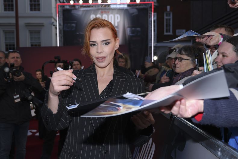 Billie Piper firma autógrafos a su llegada al estreno mundial de la película Scoop el miércoles 27 de marzo de 2024 en Londres. (Foto Vianney Le Caer/Invision/AP)