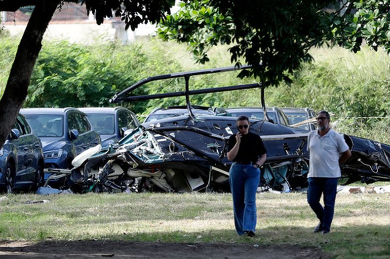 Restos de helicóptero yacen en el estacionamiento de un concesionario de automóviles donde, según la policía, dos helicópteros colisionaron en el aire y se estrellaron, en Río de Janeiro, Brasil, el domingo 14 de junio de 2026. (Foto AP/Bruna Prado)