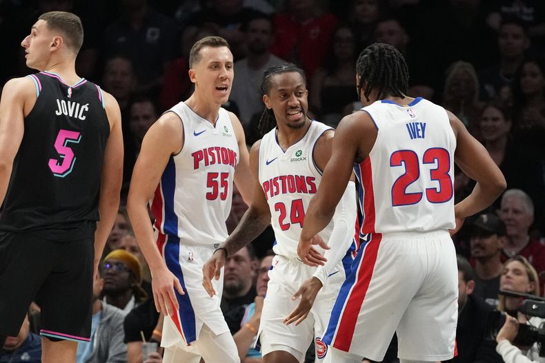 Duncan Robinson (55), alero de los Pistons de Detroit, festeja con sus compañeros Daniss Jenkins y Jaden Ivey, durante el partido ante el Heat de Miami, el sábado 29 de noviembre de 2025 (AP Foto/Marta Lavandier)