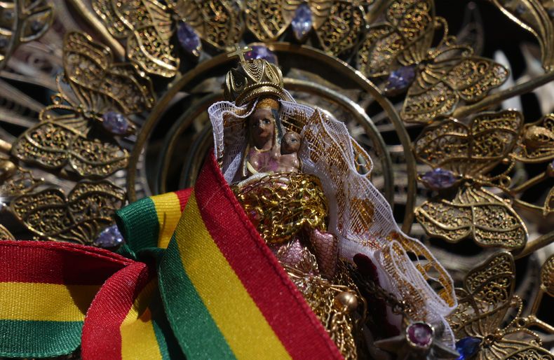 La estatua de la Virgen de las Letanías está adornada con una faja con los colores nacionales de Bolivia durante una ceremonia en honor a la pequeña virgen en su santuario en la cima de la montaña, en las afueras de Viacha, el sábado 13 de julio de 2024. (Foto AP/Juan Karita)