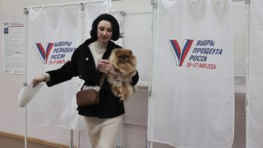 Una mujer sostiene su mascota a su salida de una cabina electoral durante las elecciones presidenciales el domingo 17 de marzo de 2024, en la ciudad portuaria de Vladivostok, en el oriente de Rusia. (AP Foto)