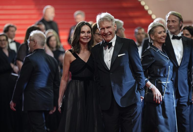 Calista Flockhart, izquierda, y Harrison Ford posan a la salida del estreno de la película Indiana Jones and the Dial of Destiny en la 76a edición del festival internacional de cine de Cannes, sur de Francia, el jueves 18 de mayo de 2023. (Foto Scott Garfitt/Invision/AP)
