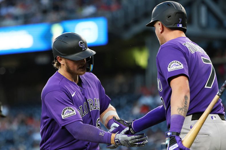 Hunter Goodman, de los Rockies de Colorado, festeja con su compañero TJ Rumfield, tras batear un jonrón ante los Nacionales de Washington, el martes 25 de agosto de 2026 (AP Foto/Daniel Kucin Jr.)