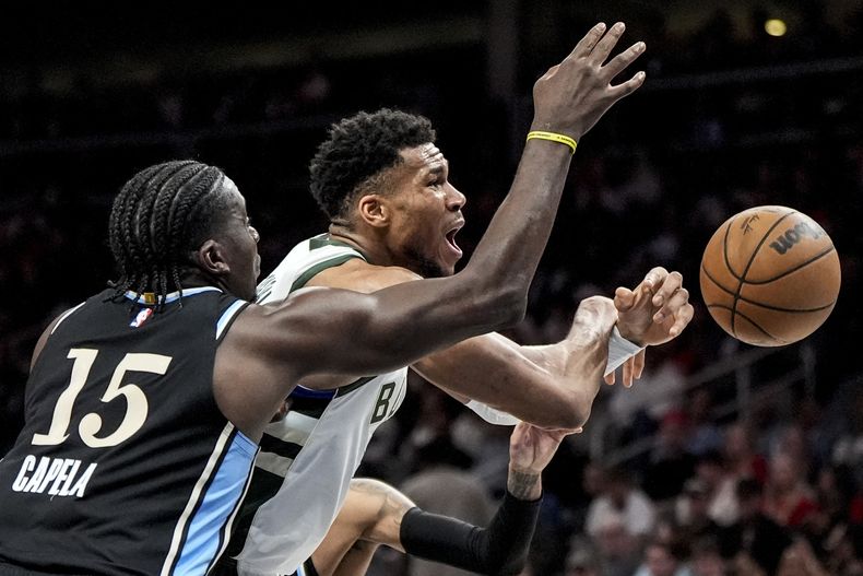 Giannis Antetokounmpo, de los Bucks de Milwaukee, trata de alcanzar un balón perdido adelante de Clint Capela, de los Hawks de Atlanta, el sábado 30 de marzo de 2024 (AP Foto/Mike Stewart)
