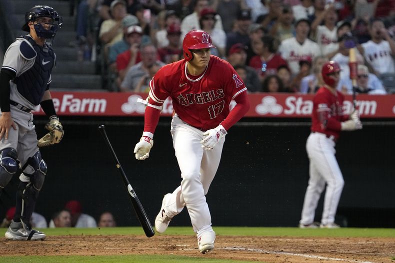 El japonés Shohei Ohtani, de los Angelinos de Los Ángeles, suelta el bate al conectar un triple frente a los Yanquis de Nueva York, el martes 18 de julio de 2023 (AP Foto/Mark J. Terrill)