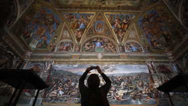 ARCHIVO - Un visitante admira una Sala de Rafael dentro de los Museos Vaticanos en el Vaticano, el 3 de mayo de 2021. (Foto AP/Alessandra Tarantino, archivo)