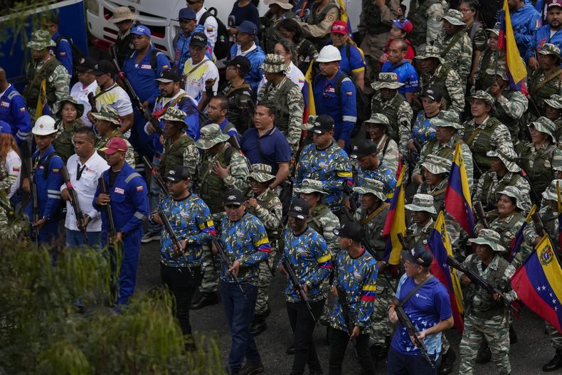 Milicianos respaldados por el gobierno avanzan por una calle en una marcha a favor del oficialismo en Caracas, Venezuela, el martes 7 de enero de 2025, en los días previos a la toma de posesión de Nicolás Maduro para un tercer mandato. (AP Foto/Matías Delacroix)