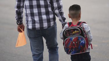 Un padre y su hijo llegan al primer día de clases, el jueves 14 de agosto de 2025, en Los Ángeles. (AP Foto/Marcio José Sánchez)