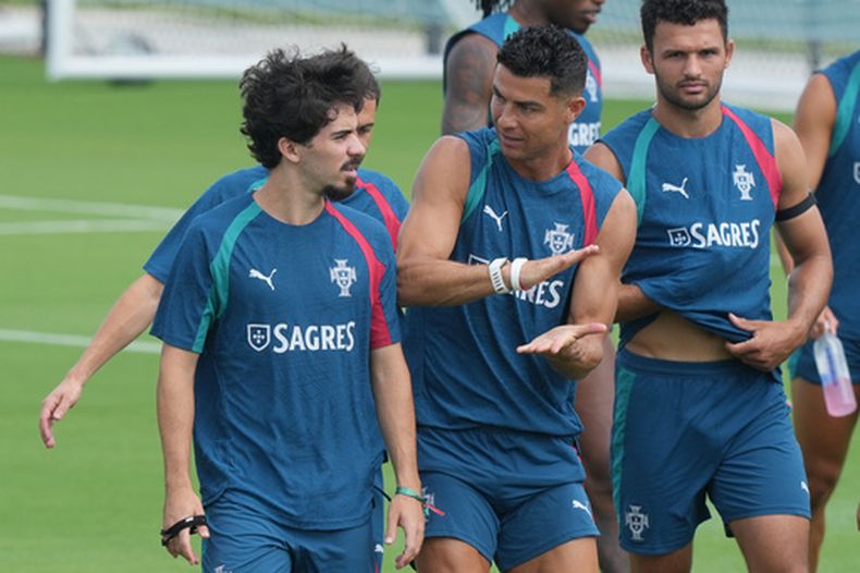Cristiano Ronaldo (centro) habla con Vitinha durante un entrenamiento de la selección de Portugal, el jueves 25 de junio de 2026, en Palm Beach Gardens, Florida (AP Foto/Marta Lavandier)