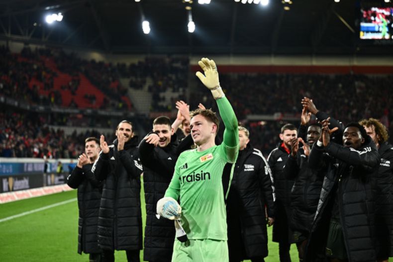 El portero de Union Berlin, Matheo Raab, centro, celebra con sus compañeros después de la victoria de su equipo en la Bundesliga ante el SC Freiburg, el domingo 15 de marzo de 2026, en Freiburgo, Alemania. (Silas Stein/dpa via AP)