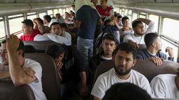 Migrantes hondureños que fueron deportados de Estados Unidos se sientan en un autobús tras llegar al aeropuerto Ramón Villeda Morales, en San Pedro Sula, Honduras, el miércoles 4 de diciembre de 2024. (AP foto/Moises Castillo)