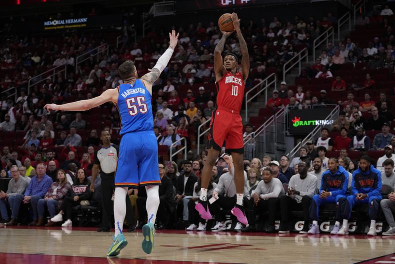 El alero de los Rockets de Houston Jabari Smith Jr. lanza el balón sobre el pívot del Thunder de Oklahoma City Isaiah Hartenstein en el encuentro del domingo primero de diciembre del 2024. (AP Foto/Ashley Landis)