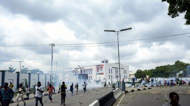 ARCHIVO - Personas huyen de los gases lacrimógenos durante una protesta callejera en Kano, Nigeria, el 1 de agosto de 2024. (Foto AP/Sani Maikatanga, Archivo)