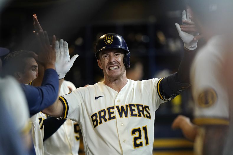 Mark Canha, de los Cerveceros de Milwaukee, es felicitado en la caseta del equipo después de batear un cuadrangular solitario durante la primera entrada del juego de béisbol en contra de los Marlins de Miami, el lunes 11 de septiembre de 2023, en Milwaukee. (AP Foto/Aaron Gash)