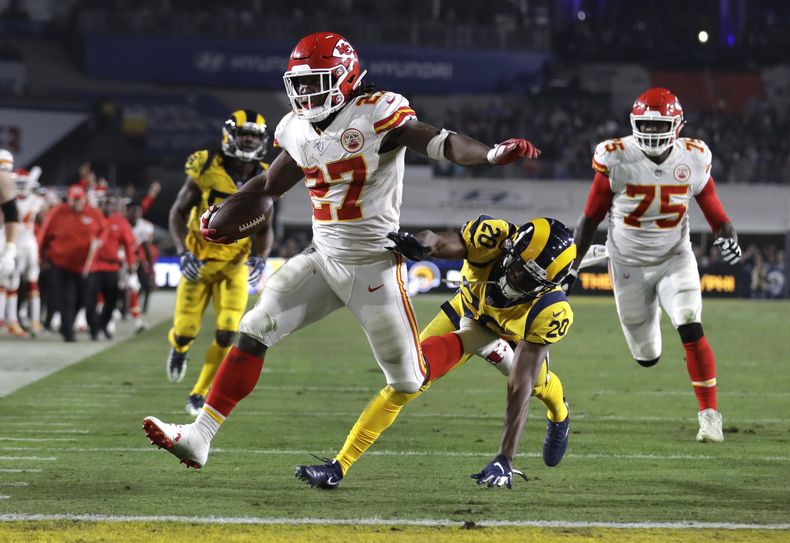 ARCHIVO - Kareem Hunt (27), running back de los Chiefs de Kansas City, anota un touchdown superando al safety Lamarcus Joyner (20), de los Rams de Los Ángeles, mientras observa el liniero ofensivo Cameron Erving (75) durante la primera mitad del juego de la NFL del lunes 19 de noviembre de 2018, en Los Ángeles. (AP Foto/Marcio Jose Sanchez, Archivo)