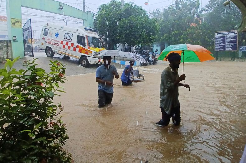 Gente caminando frente al hospital gubernamental de Tambaram, inundado tras las fuertes lluvias en Chennai, India, el lunes 4 de diciembre de 2023. (Foto AP)