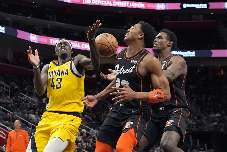 El alero de los Pacers de Indiana Pascal Siakam (43) y el escolta de los Pistons de Detroit Jaden Ivey (23) pierrden un rebote durante la segunda mitad del juego de baloncesto de la NBA, el miércoles 20 de marzo de 2024, en Detroit. (AP Foto/Carlos Osorio)
