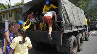 Residentes suben a un camión militar para evacuar sus casas en la localidad de Santo Domingo, en la provincia de Albay, en el noreste de Filipinas, por la erupción de un volcán, el 13 de junio de 2023. (AP Foto/Aaron Favila)