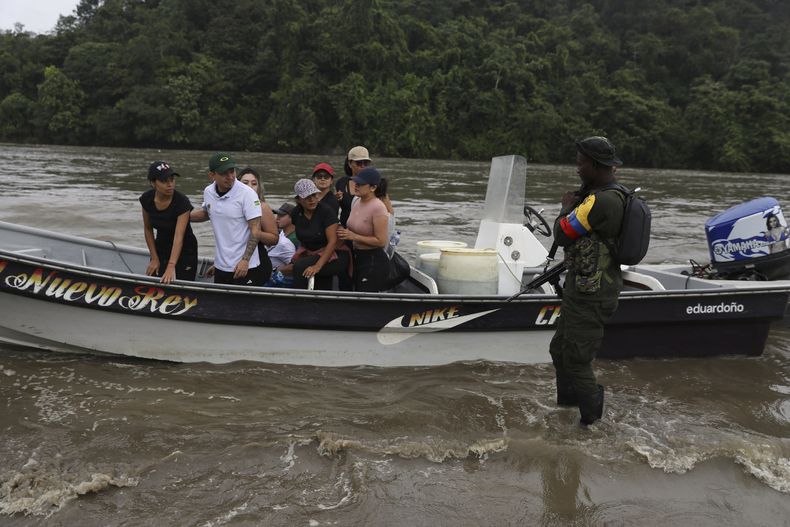 Contratistas de la Gobernación del Cauca, en un bote, siendo liberados por miembros del Estado Mayor Central (EMC), una disidencia de la guerrilla FARC que no se acogió al acuerdo de paz, tras el secuestro días antes en López de Micay en la costa sur del Pacífico colombiano, el viernes 25 de julio de 2025. (AP Foto/Santiago Saldarriaga)