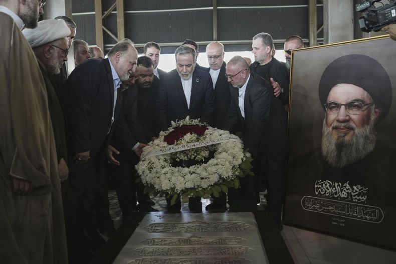 El ministro de exteriores iraní Abbas Araghchi (centro) coloca flores en la tumba del asesinado líder de Hezbollah Hasán Nasrala en los suburbios del sur de Beirut, Líbano, el 3 de junio del 2025. (AP foto/Hassan Ammar)