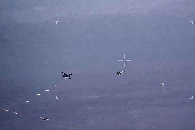 Imagen tomada de un video publicado por la Fuerza Aérea de EE.UU., en la que se observan cazas rusos SU-34 y SU-35 lanzando bengalas en la ruta de vuelo de un dron MQ-9 Reaper de la Fuerza Aérea de EE.UU. (abajo, a la izquierda) el jueves 6 de julio de 2023 sobre Siria. (Fuerza Aérea de EE.UU. vía AP)