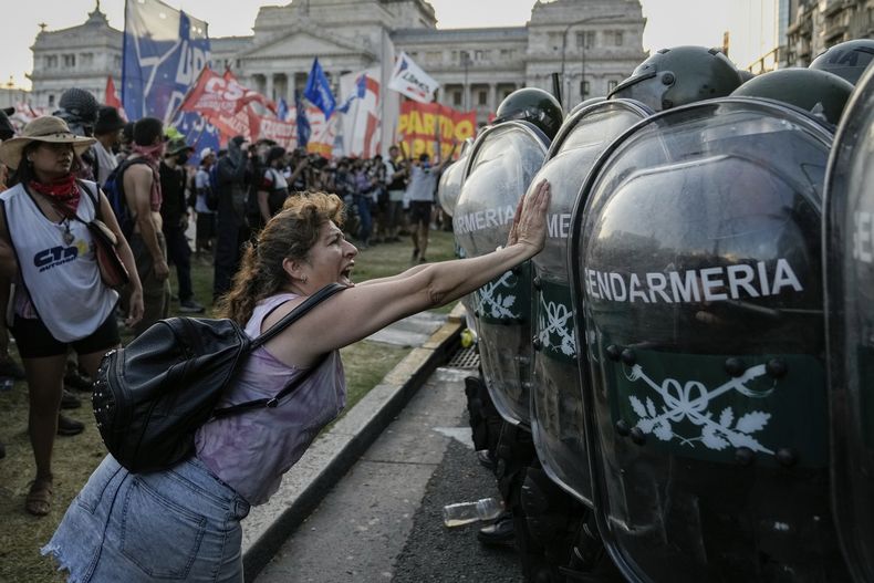 Una manifestante antigobierno empujan a la policía que custodia el Congreso donde los legisladores debaten una reforma impulsada por el presidente argentino, Javier Milei, en Buenos Aires, Argentina, el jueves 1 de febrero de 2024. La propuesta incluye una amplia variedad de medidas económicas, administrativas, penales y medioambientales. (AP Foto/Rodrigo Abd)
