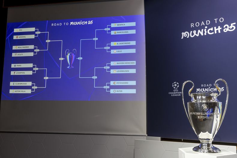 Imagen que muestra los emparejamientos en los octavos de final de la Liga de Campeones de Europa a un costado del trofeo que se entrega al campeón del torneo, durante el sorteo de la Liga de Campeones en la sede de la UEFA, en Nyon Suiza, el viernes 21 de febrero de 2025. (Salvatore Di Nolfi/Keystone via AP)