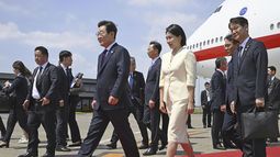 El presidente de Corea del Sur, Lee Jae Myung (centro, izquierda), y su esposa, Kim Hea Kyung (centro), a su llegada al aeropuerto de Haneda, en Tokio, Japón, el 23 de agosto de 2025. (Kyodo News vía AP)
