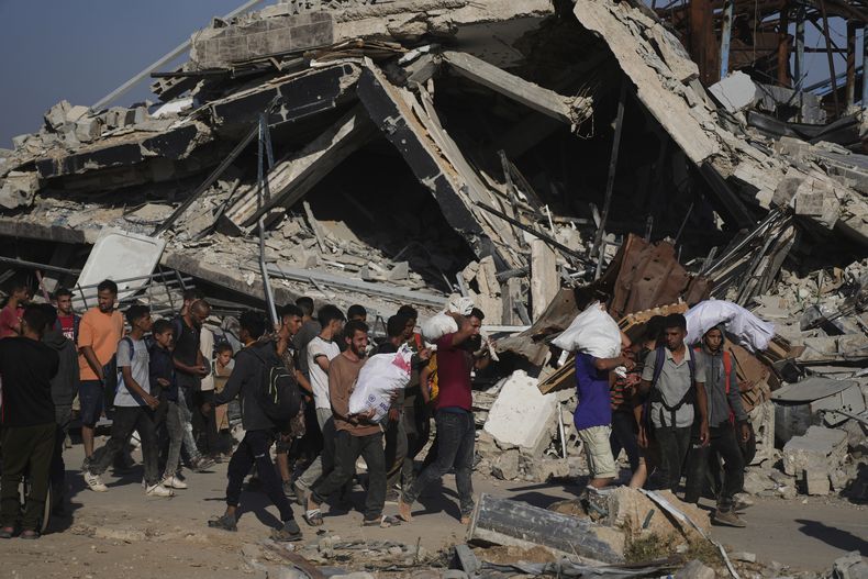 Palestinos cargan paquetes de ayuda distribuidos por la Fundación Humanitaria de Gaza, operada por una organización respaldada por EEUU, en Jan Yunis, en el sur de la Franja de Gaza, el 26 de junio de 2025. (AP Foto/Abdel Kareem Hana)