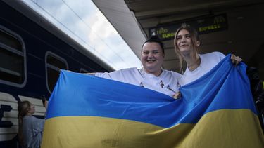 La rapera ucraniana alyona alyona, izquierda, y la cantante Jerry Heil posan para medios con la bandera ucraniana antes de partir en una estación de tren en Kiev, Ucrania, el jueves 25 de abril de 2024. El dúo representará a Ucrania en el festival Eurovisión en Malmö, Suecia. (Foto AP/Francisco Seco)