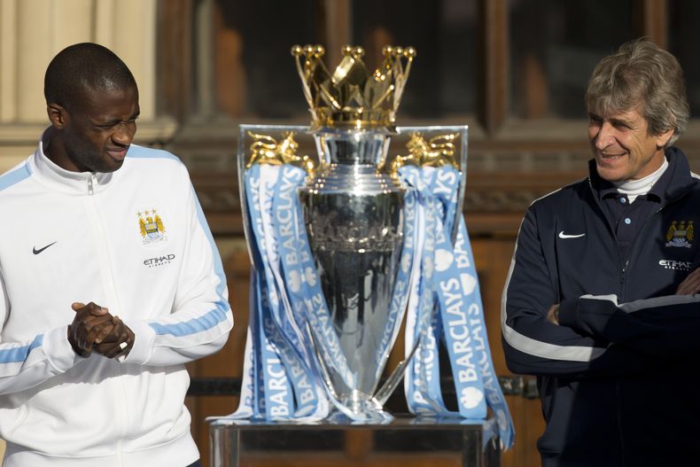 El jugador de Manchester City, Yaya Tour&eacute;, izquierda, y el t&eacute;cnico Manuel Pellegrini posan con el trofeo de campeones de la liga Premier el lunes, 12 de mayo de 2014, en Manchester, Inglaterra. (AP Photo/Jon Super)