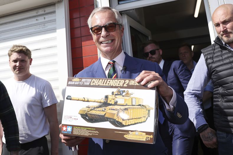 El líder de Reform UK, Nigel Farage, muestra un modelo a escala de un tanque británico que le obsequiaron en la campaña con la candidata a alcaldesa de Reform UK, Andrea Jenkyns, en Scunthorpe, Inglaterra, el martes 29 de abril de 2025. (AP Foto/Darren Staples)