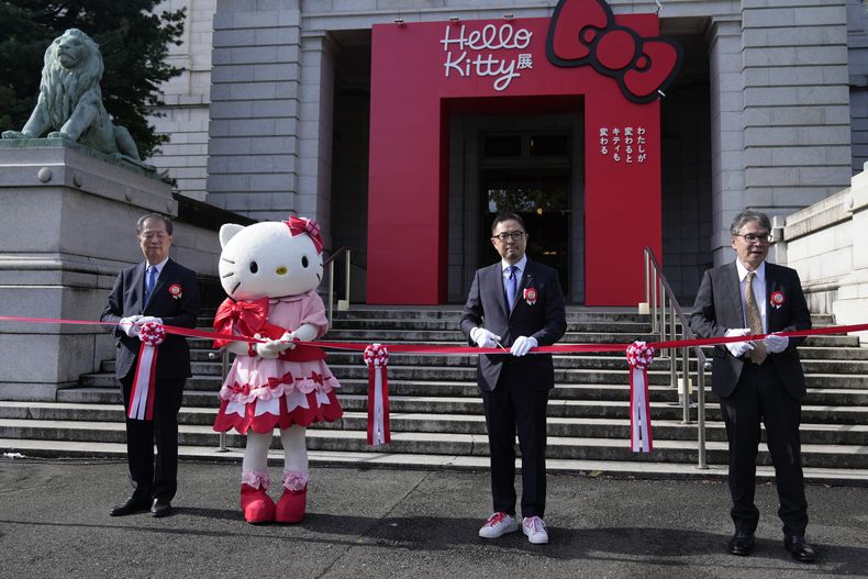Hello Kitty, segunda de izquierda a derecha, con Makoto Fujiwara, director ejecutivo del Museo Nacional de Tokio, a la izquierda, el director general senior de Sanrio, Yasuyuki Otsuka, segundo a la derecha, y Keiichi Sawa, a la derecha, director general de Nippon TV, asisten a la ceremonia de inauguración de la exposición A medida que yo cambio, ella también, que conmemora el 50 aniversario de Hello Kitty en el Museo Nacional de Tokio el miércoles 30 de octubre de 2024. (Foto AP/Shuji Kajiyama)