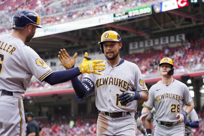 Blake Perkins (centro), de los Cerveceros de Milwaukee, festeja con Owen Miller, luego de batear un grand slam ante los Rojos de Cincinnati, el sábado 3 de junio de 2023 (AP Foto/Jeff Dean)