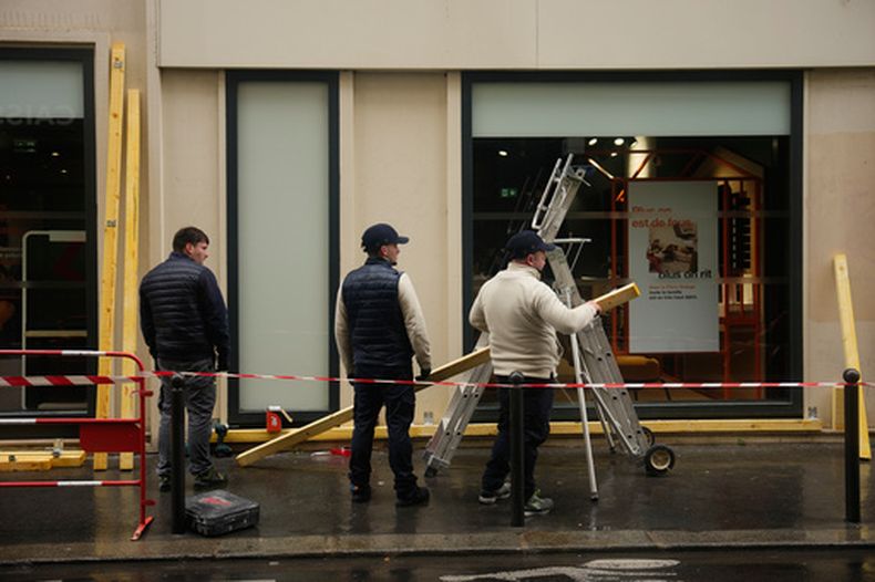 Trabajadores colocan barreras en un comercio ante la amenaza de disturbios en París, el 23 de octubre del 2026. (AP foto/Teresa Suarez)