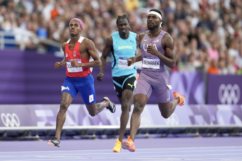 Kenneth Bednarek, de Estados Unidos, cruza la meta en los 200 metros seguido por el dominicano Alexander Ogando (izquierda), de la República Dominicana, en los Juegos Olímpicos de París 2024, el miércoles 7 de agosto del 2024 en Saint-Denis, Francia. (AP Foto/Ashley Landis)