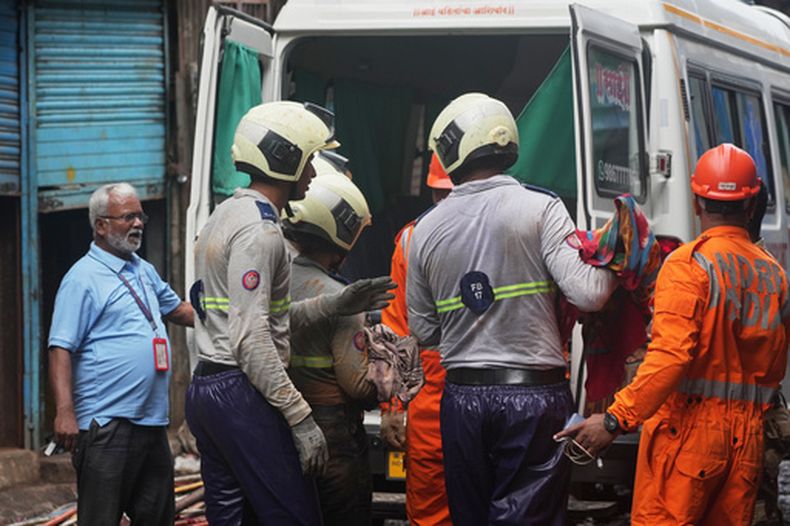 Rescatistas trasladan el cuerpo de una víctima a una ambulancia tras un deslave en un barrio pobre en Mumbai, India, el 12 de agosto de 2026. (AP Foto/Rafiq Maqbool)