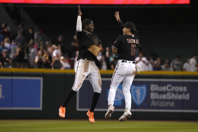El dominicano Geraldo Perdomo y Alek Thomas, de los Diamondbacks de Arizona, festejan la victoria sobre los Marineros de Seattle, el sábado 29 de julio de 2023 (AP Foto/Rick Scuteri)