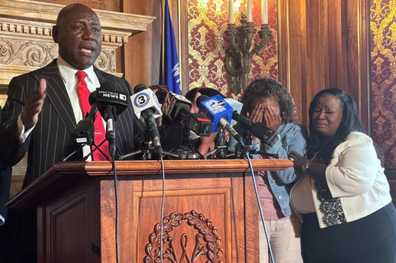 El abogado Ben Crump, izquierda, habla en conferencia de prensa sobre Corey Ruiz, quien murió a manos de la policía de Madison, mientras su hermana Veronica Ruiz, segunda de derecha a izquierda, rompe a llorar y recibe consuelo de la representante estatal de Wisconsin Shelia Stubbs, demócrata por Madison, el viernes 24 de julio de 2026, en Madison, Wisconsin. (Foto AP/Scott Bauer)