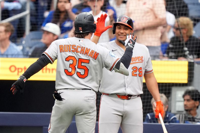 Adley Rutschman, de los Orioles de Baltimore, festeja con el dominicano Samuel Basallo luego de conseguir un jonrón ante los Azulejos de Toronto, el viernes 5 de junio de 2026 (Nathan Denette/The Canadian Press via AP)