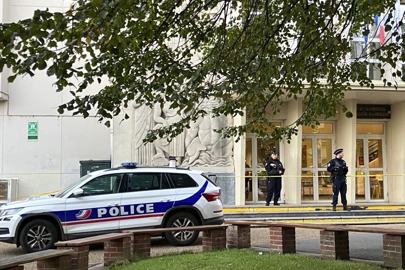 Agentes de policía montan guardia ante la escuela secundaria donde un hombre apuñaló a un profesor, el sábado 14 de octubre de 2023 en Arras, en el norte de Francia. (AP Foto/Jeffrey Schaeffer)