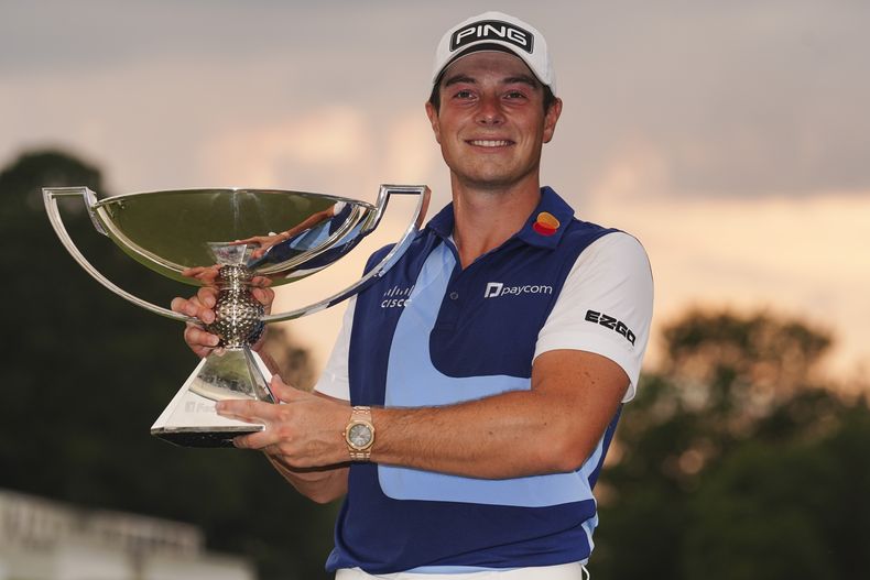 Viktor Hovland, de Noruega, celebra después de ganar el torneo Tour Championship de golf, con el trofeo de la Copa FedEx en green del hoyo 18, el domingo 27 de agosto de 2023, en Atlanta. (AP Foto/John Bazemore)