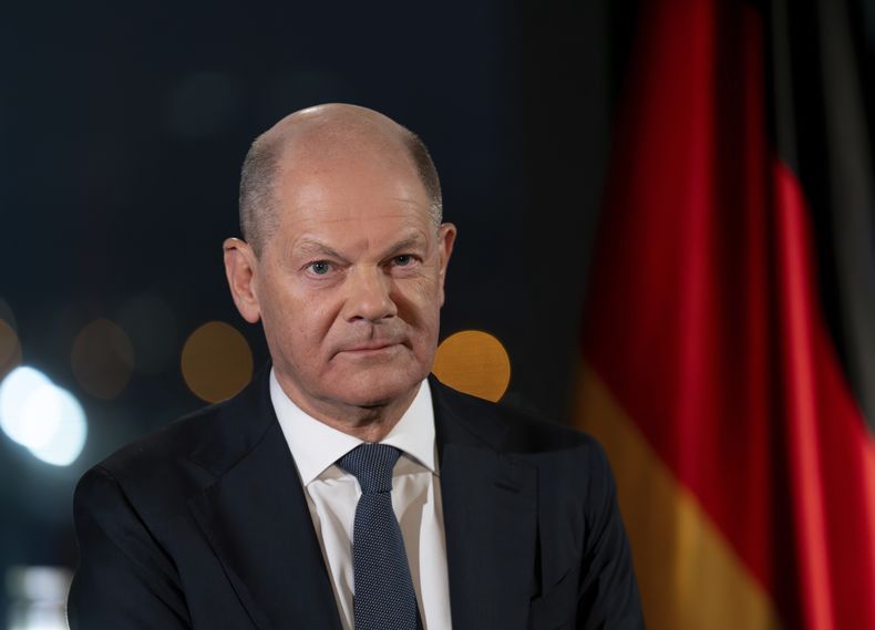 El canciller alemán, Olaf Scholz, con el Reichstag como telón de fondo, iluminado por reflectores, en una sesión fotográfica tras la grabación de su discurso de Año Nuevo en la Cancillería, en Berlín, Alemania, el 29 de diciembre de 2024. (Soeren Stache/dpa vía AP)