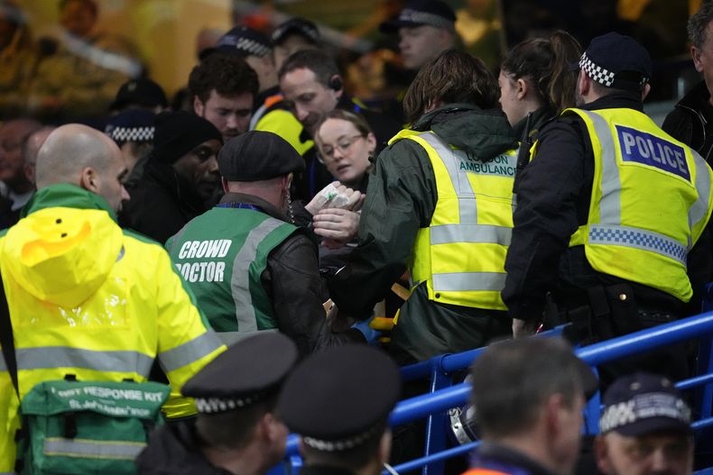 El cuerpo médico y la policía atienden a un fanático que cayó desde la grada superior durante el partido de quinta ronda en la Copa FA entre el Chelsea y Leeds United, en Stamford Bridge, en Londres, el miércoles 28 de febrero de 2024. (AP Foto/Kirsty Wigglesworth)
